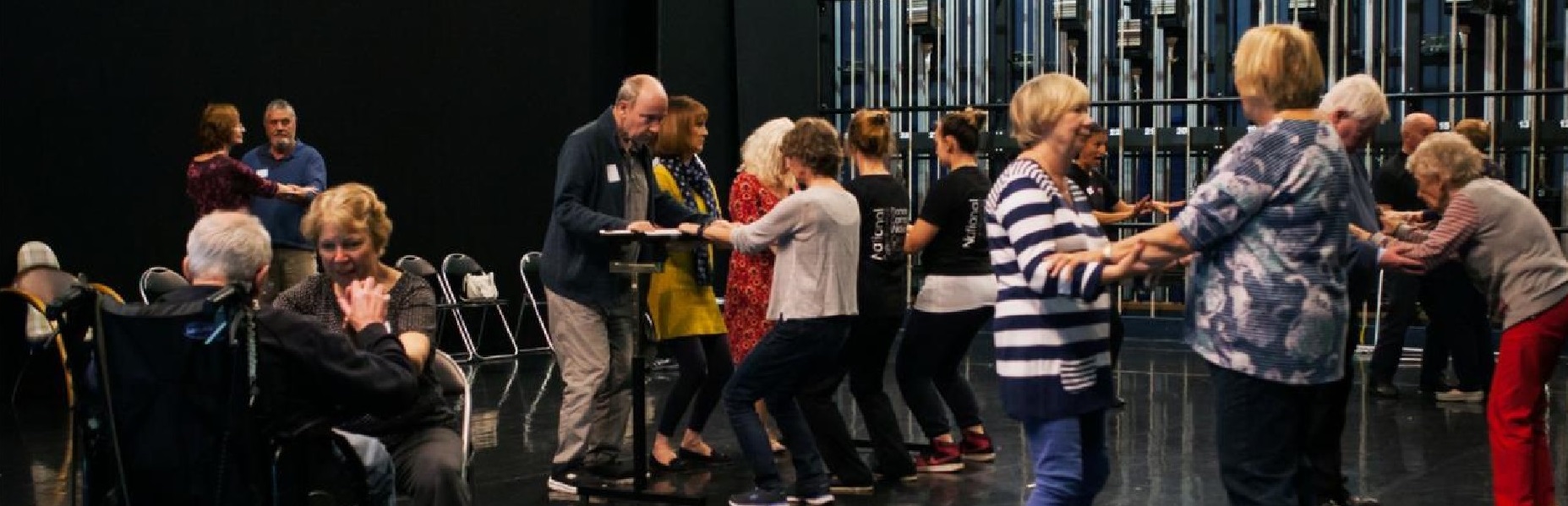 Eleven older people and three National Dance Company members, dancing.