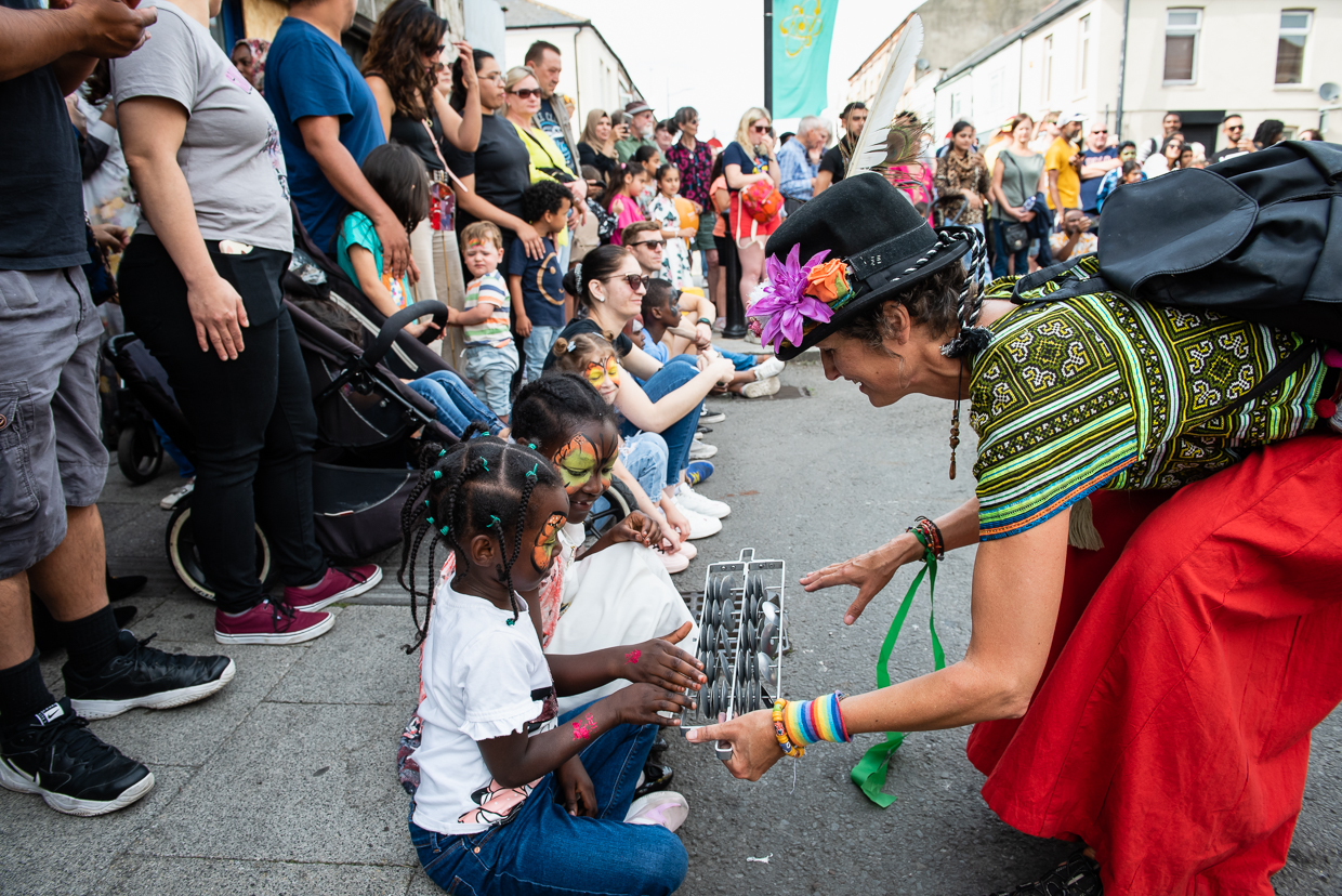 A NoFit State Circus performer engages with a crowd of people at the Clifton Street Festival
