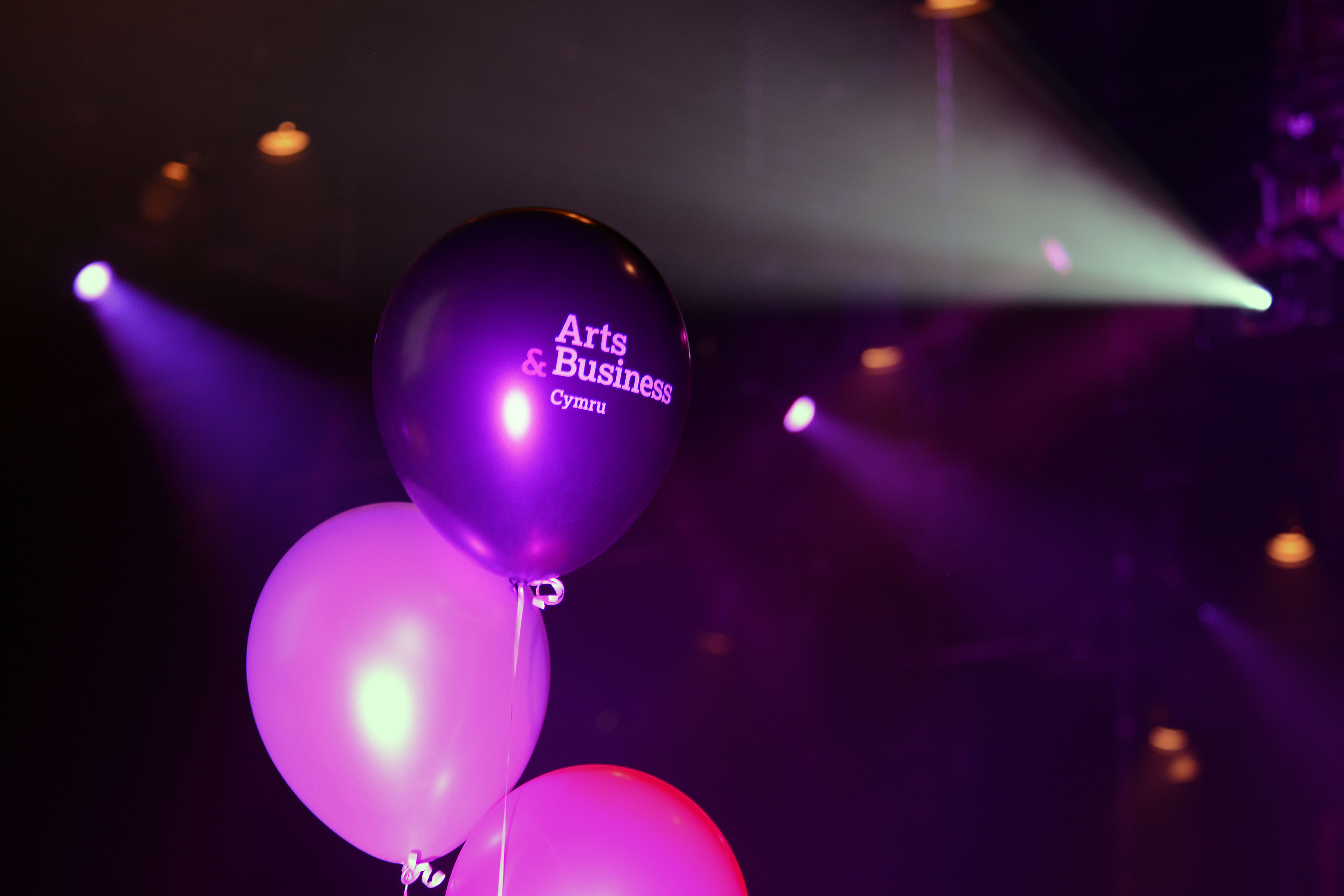 A black balloon featuring the Arts & Business Cymru logo