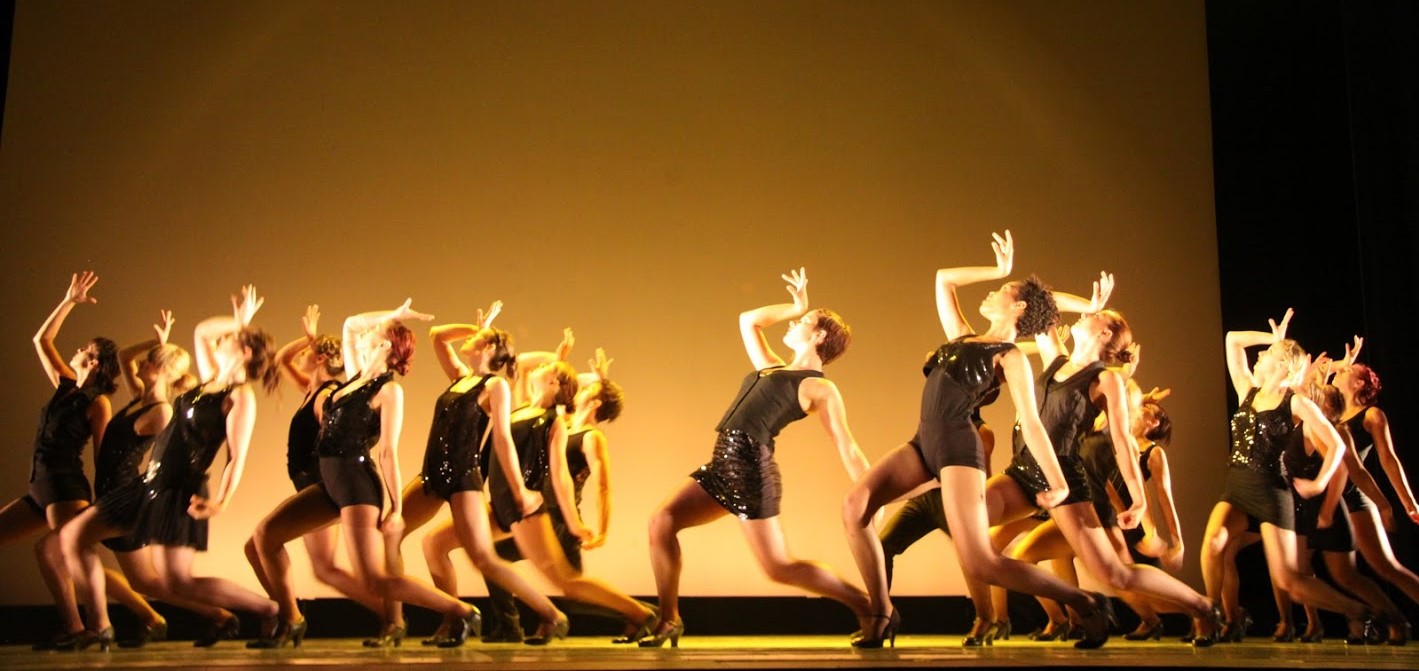 A number of Rubicon dancers on stage wearing black and striking a pose