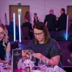 People sat at a dinner table reading a card