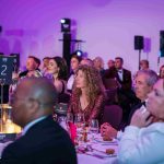 People sat at a dinner table watching a live performance