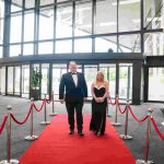 Two people walking down a red carpet and smiling