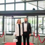 Two people standing on a red carpet